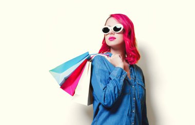 renkli bir alışveriş torbaları tutan güneş gözlüklü kız