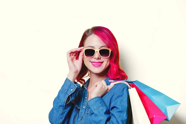 Dívka v sluneční brýle drží barevné nákupní tašky — Stock fotografie