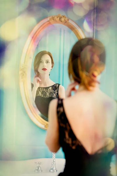 Jovem mulher olhando para o espelho — Fotografia de Stock