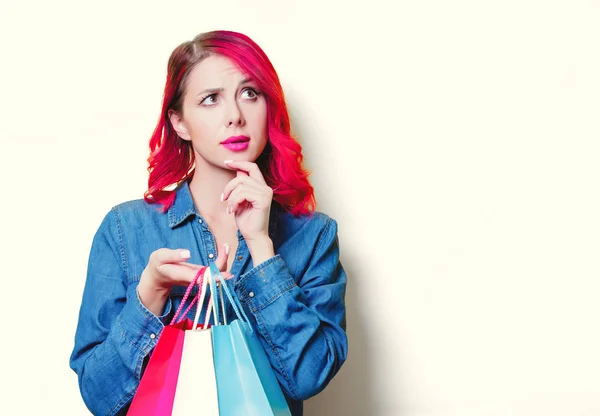 Lány a kék ing gazdaság egy színes bevásárló táskák — Stock Fotó