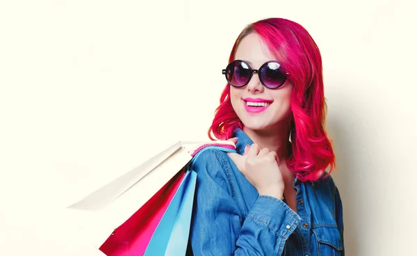 Chica en gafas de sol sosteniendo un color bolsas de compras — Foto de Stock