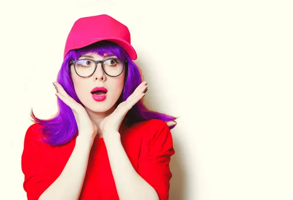 Mujer joven sorprendida en gorra y gafas — Foto de Stock