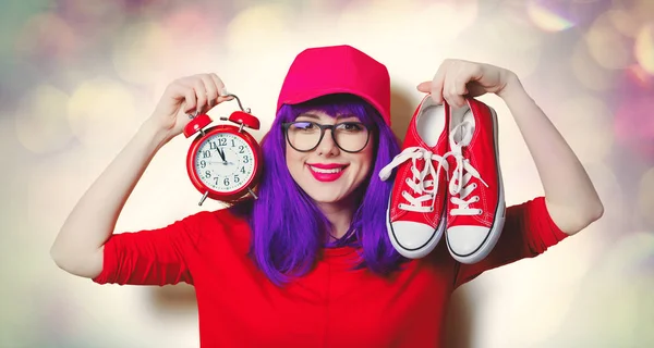 Mujer joven con zapatos de goma y despertador —  Fotos de Stock