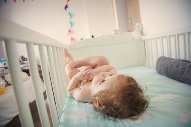 Küçük bebek evde bir yatakta yatarken
