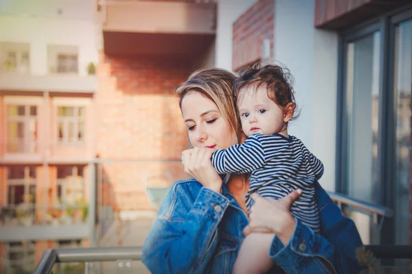 Young mother with a child standing on balcony — Stock Photo, Image