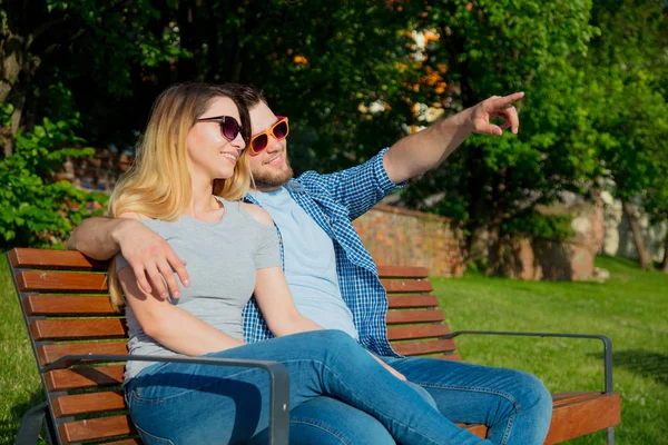 Young couple sitting on bench — Stock Photo, Image