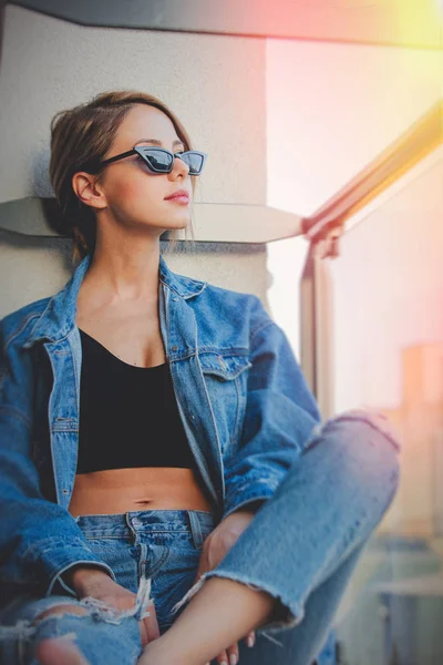 女孩牛仔裤衣服和太阳镜在阳台上 — 图库照片