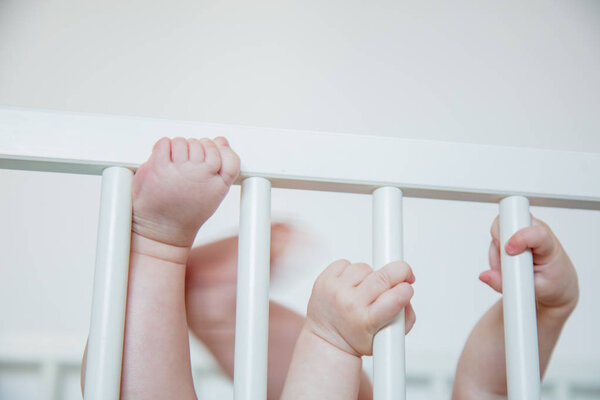 Child hands holding a bed handrail