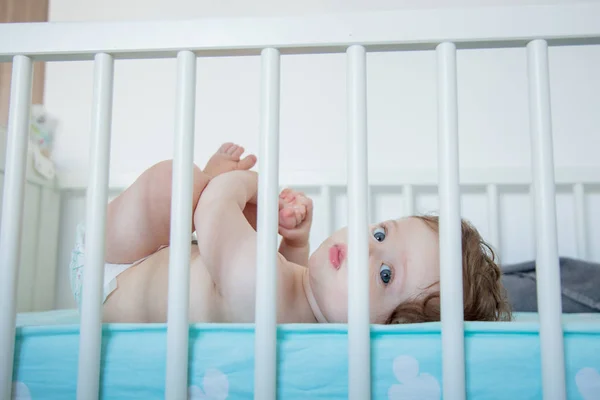 Küçük bebek evde bir yatakta yatarken — Stok fotoğraf