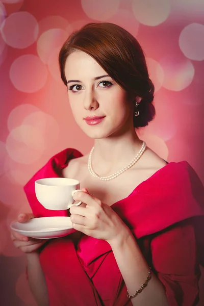 Mujer en ropa de época victoriana roja con taza de té — Foto de Stock