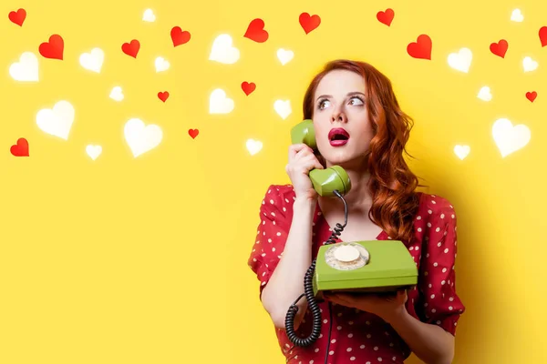 Niña en vestido rojo con teléfono de línea verde y corazones —  Fotos de Stock