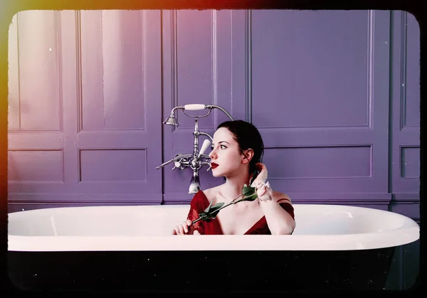 Junge Frau in Badewanne mit Blume — Stockfoto