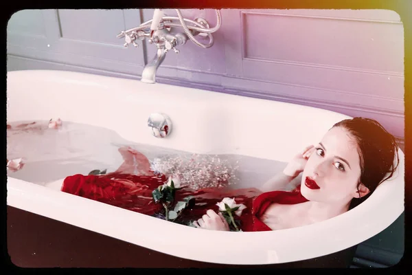 Junge Frau im Bad mit Blumen — Stockfoto