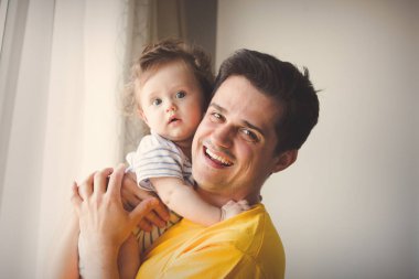 evde küçük bir bebekle oynarken baba.