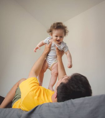 evde küçük bir bebekle oynarken baba.
