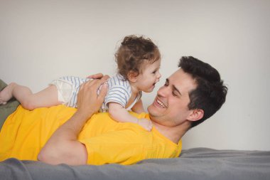 evde küçük bir bebekle oynarken baba.