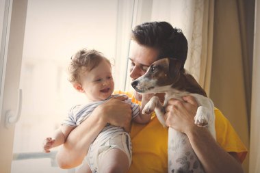 evde küçük bir bebekle oynarken baba.