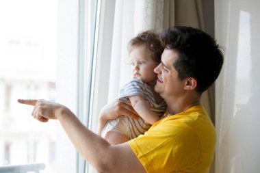 evde küçük bir bebekle oynarken baba.