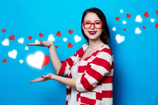 Frau auf blauem Hintergrund mit Herzen — Stockfoto