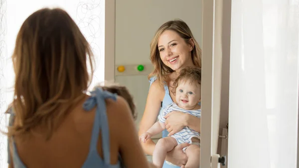 Mère et un petit enfant près d'un miroir — Photo