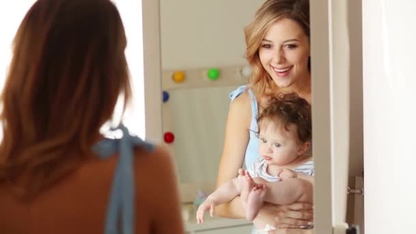 Mor och ett litet barn nära en spegel — Stockvideo