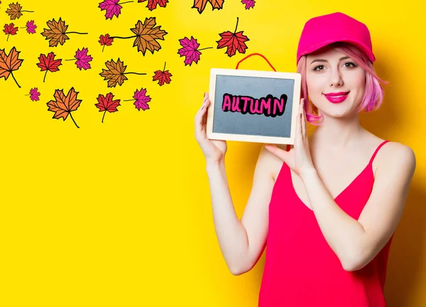 Giovane ragazza in cappello rosa con tavola e foglie — Foto Stock