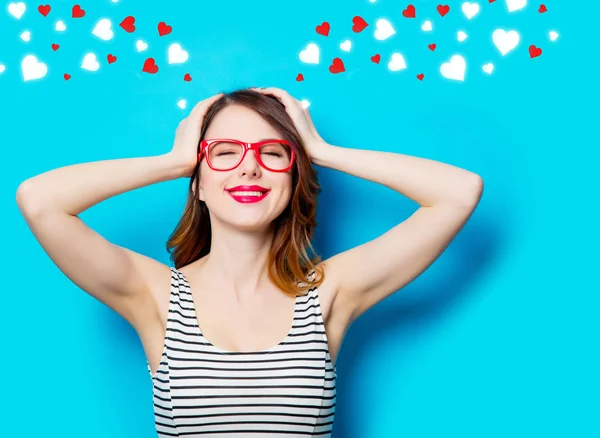 Joven mujer sonriente en gafas y corazones abstractos — Foto de Stock