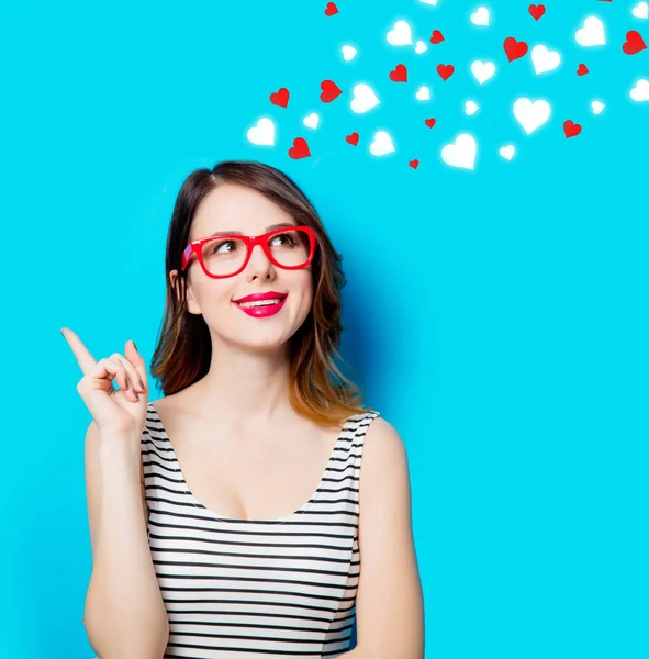 Young smiling woman in glasses and abstract hearts — Stock Photo, Image