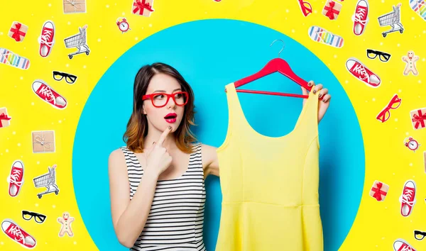 Junge Frau mit Kleid auf Kleiderbügel und mit Kleidung — Stockfoto