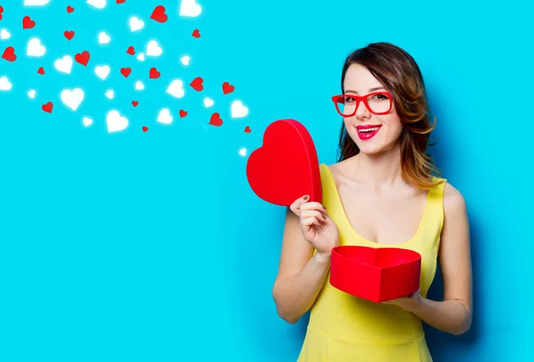 Young woman with gift and abstract hearts — Stock Photo, Image