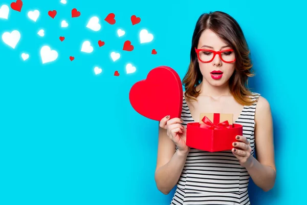 Young woman with gift in box and abstract hearts — Stock Photo, Image
