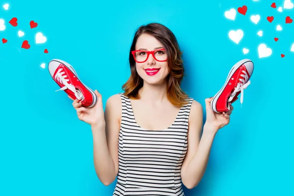 Young woman with gumshoes and abstract hearts — Stock Photo, Image