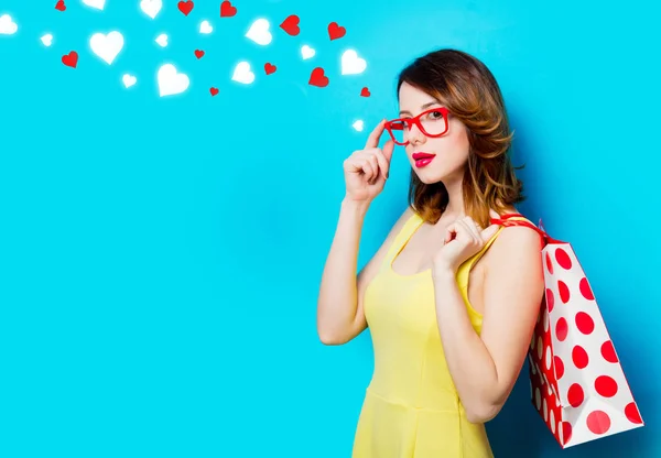 Young woman with shopping bag and abstract hearts — Stock Photo, Image