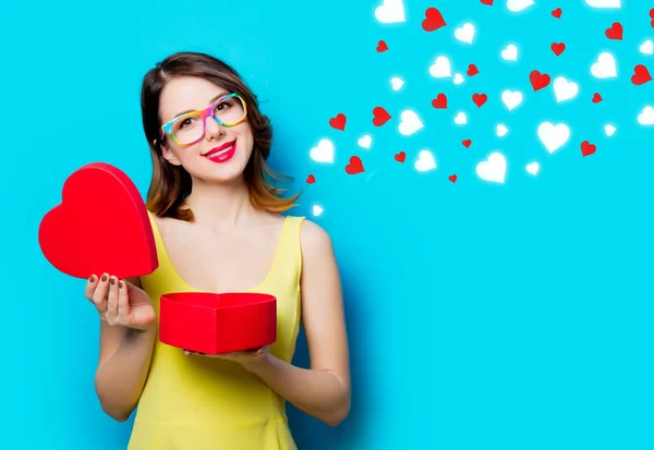 Mujer joven con regalo y corazones abstractos —  Fotos de Stock