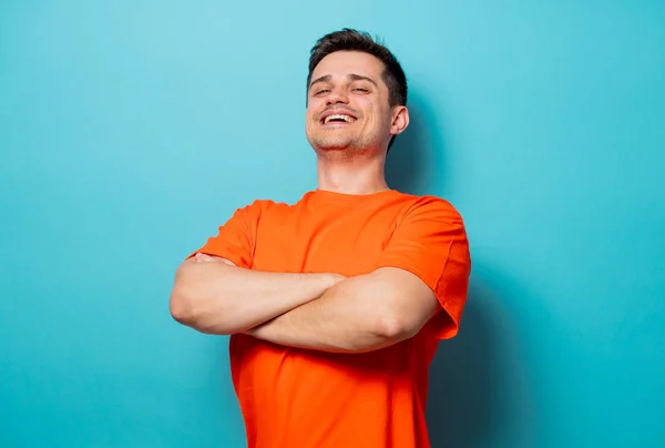 Jonge knappe man in oranje t-shirt — Stockfoto