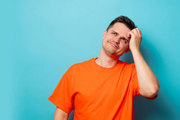 Junger schöner Mann in orangefarbenem T-Shirt — Stockfoto