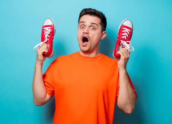 Hombre guapo en camiseta naranja con zapatos de goma rojos —  Fotos de Stock