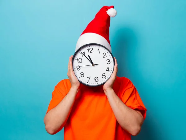 クリスマス帽子と大きな時計を持つ男 — ストック写真