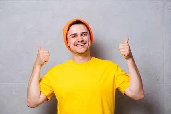 Homem bonito em camiseta amarela e chapéu laranja — Fotografia de Stock