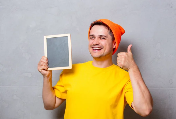 Homem de t-shirt amarela com quadro negro — Fotografia de Stock