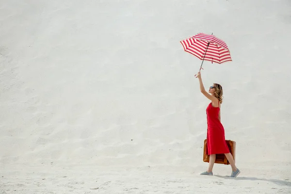 傘とビーチでスーツケースの赤いドレス — ストック写真