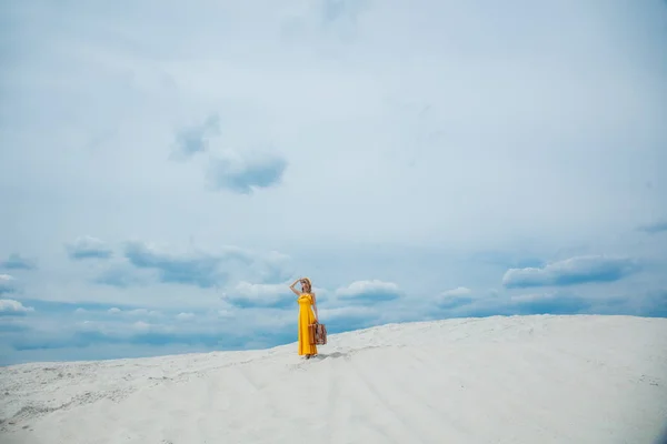 Nő a sárga ruha bőrönd a strandon — Stock Fotó