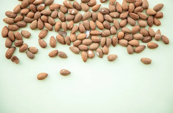 Almonds isolated on green background — Stock Photo, Image