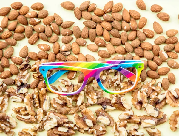 Almonds and walnuts with LGBT colors glasses — Stock Photo, Image