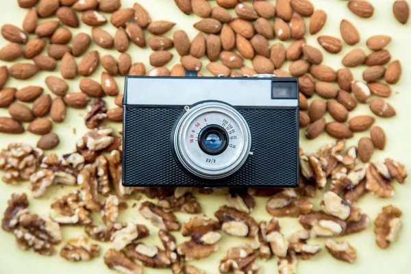 Almonds and walnuts with vintage camera — Stock Photo, Image