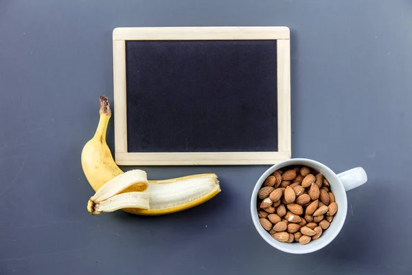 White cup full of almond with banana — Stock Photo, Image