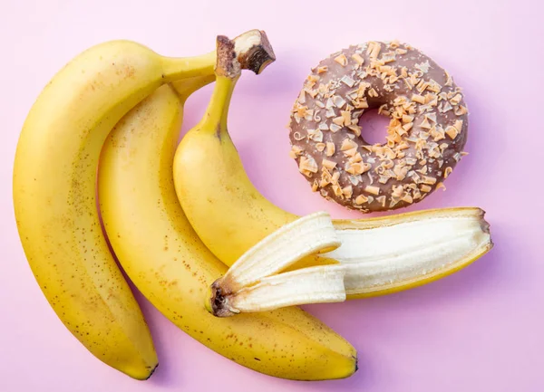 노란색 바나나와 분홍색 배경에 도넛 — 스톡 사진