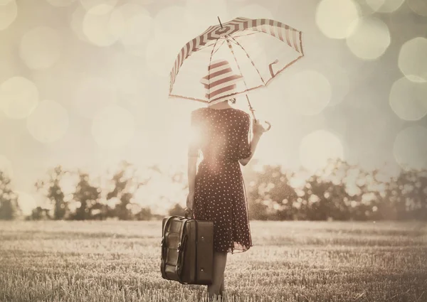 Mujer joven con paraguas y maleta — Foto de Stock