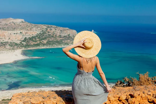 Girl in hat and dress with sea coastline — Stock Photo, Image