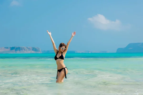 Chica pelirroja joven en bikini negro en la playa de Balos —  Fotos de Stock